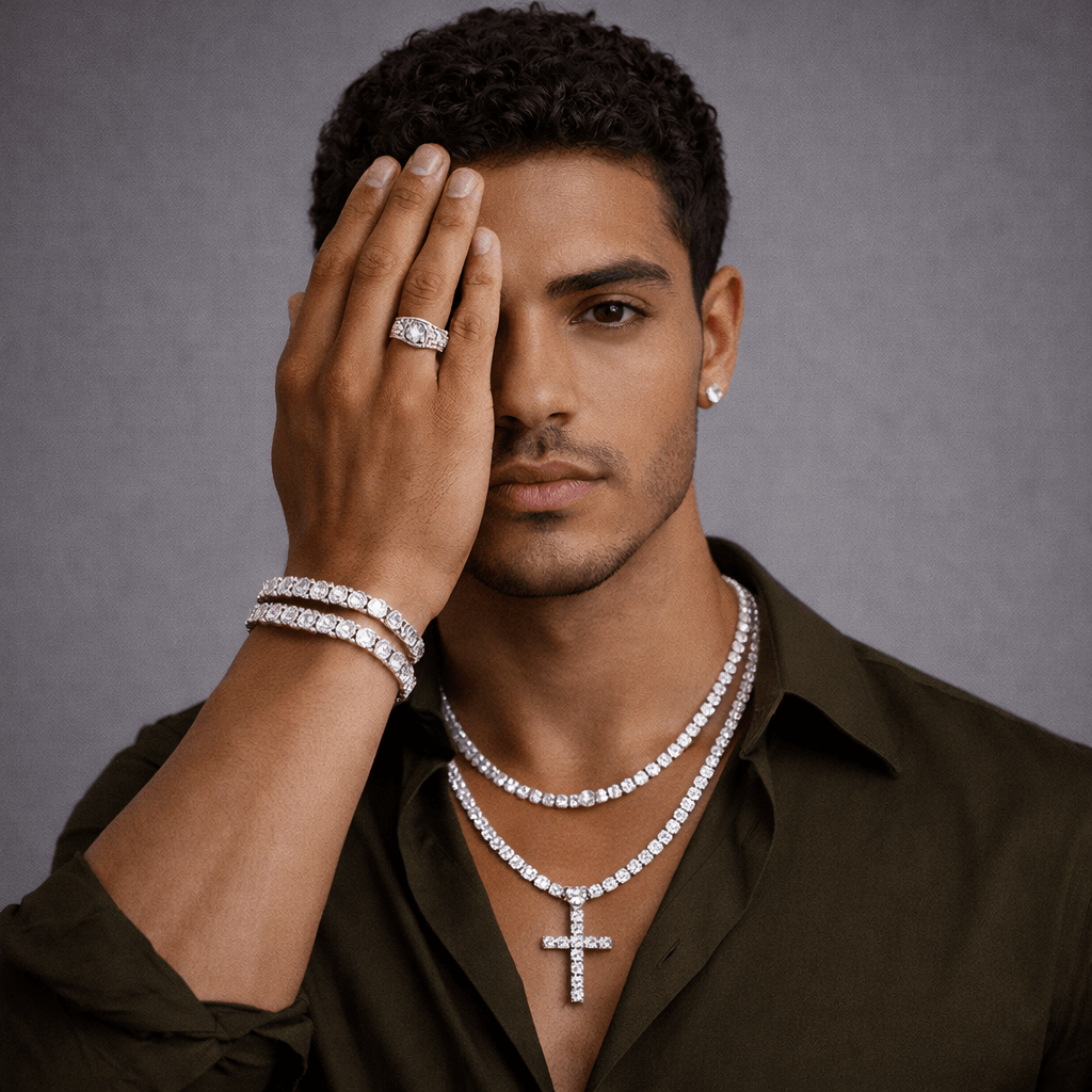 Man wearing diamond jewelry including a ring, bracelet, and necklace on a gray background