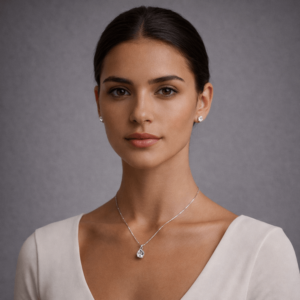 Woman wearing a silver necklace and earrings against a gray background